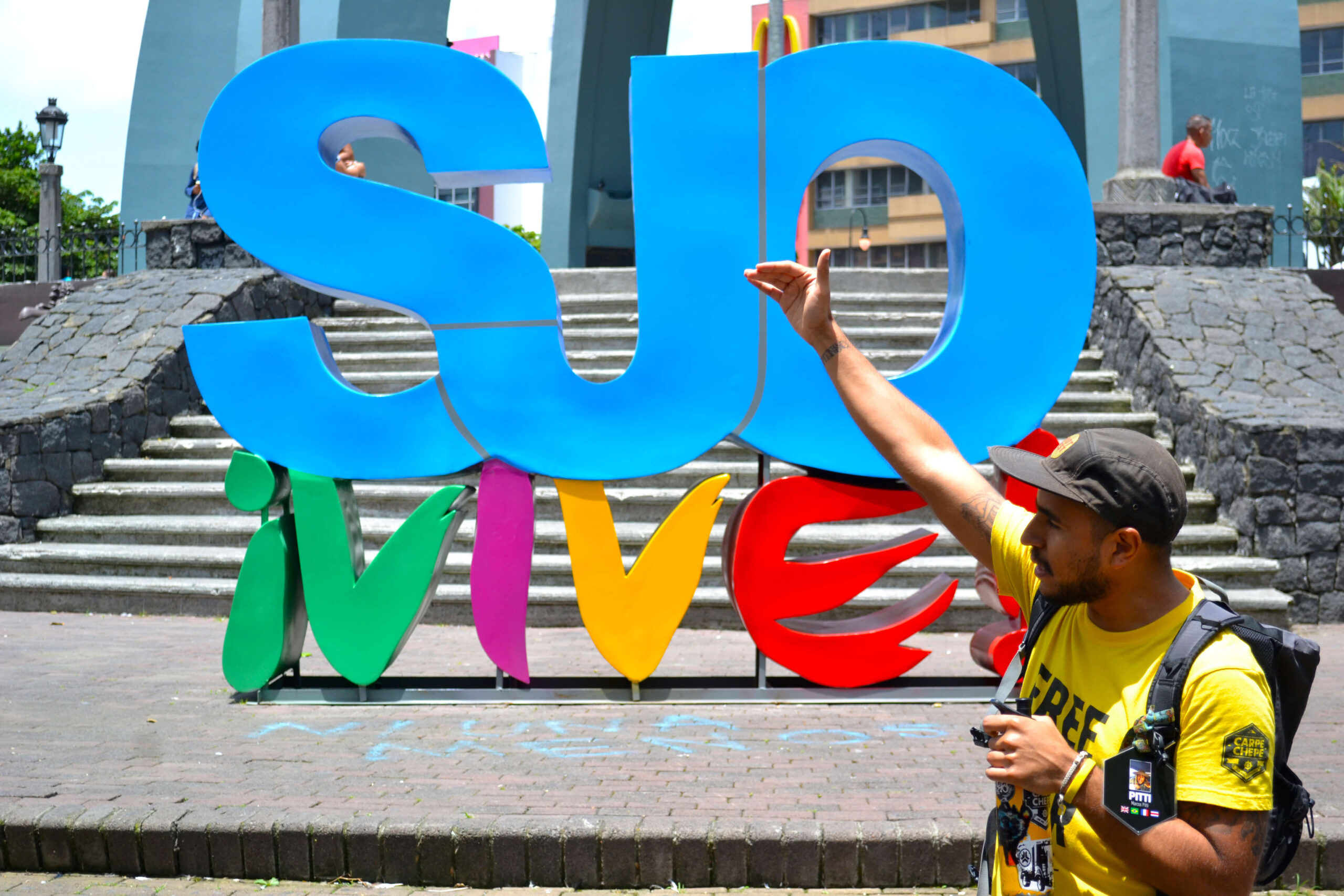 Marcos Pitti guiando un tour urbano frente al monumento SJO ¡Vive! en San José, Costa Rica